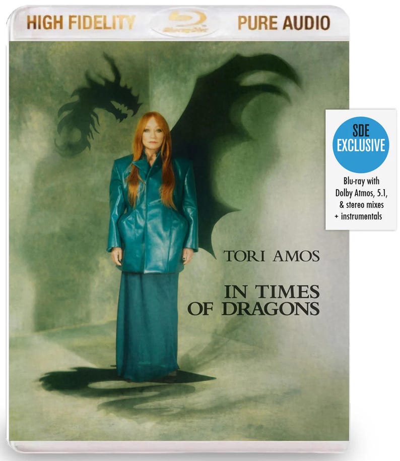 May include: Blu-ray disc case featuring Tori Amos. The cover art shows a woman in a teal outfit with a dragon silhouette. Text includes "HIGH FIDELITY", "PURE AUDIO", "TORI AMOS", and "IN TIMES OF DRAGONS". A sticker indicates "SDE EXCLUSIVE".