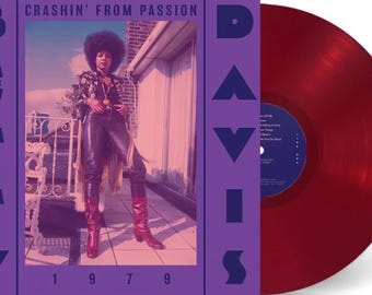 May include: A red vinyl record with a purple album cover featuring a woman with an afro wearing leather pants and boots. The album cover has the text "BETTY DAVIS" and "CRASHIN' FROM PASSION" in large, bold, blue letters. The year "1979" is printed in white at the bottom of the cover.