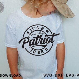 May include: A white t-shirt with a black circle design that says "It's a great day to be a Patriot".
