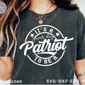 May include: A gray t-shirt with a white circle design that says "It's a great day to be a Patriot" in a vintage style font.
