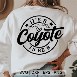 May include: White sweatshirt with a black graphic that reads "It's a great day to be a Coyote." The design includes stars, a heart, and the word "Coyote" in a bold, cursive font. The bottom of the image includes the text "SVG | DXF | EPS | PNG."