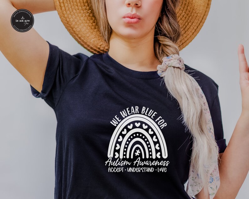 May include: A black t-shirt with a white rainbow design and the text "We wear blue for Autism Awareness Accept - Understand - Love".