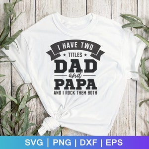 May include: White t-shirt with black text that reads "I have two *titles* DAD and PAPA and I rock them both".