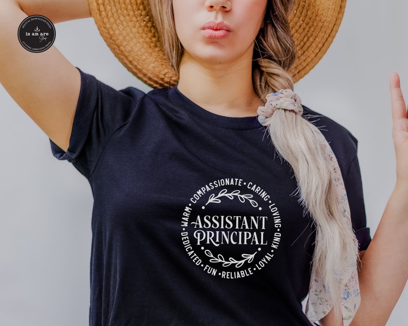 May include: A navy blue t-shirt with the words "Assistant Principal" in a white circular design. The design includes the words "Warm, Compassionate, Caring, Loving, Kind, Loyal, Reliable, Fun, Dedicated" around the central text.