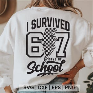 May include: White sweatshirt with a black graphic that reads "I SURVIVED 67 DAYS OF SCHOOL". The number 67 is in a bold font with a checkered lightning bolt in the middle. The words "DAYS OF School" are in a script font.