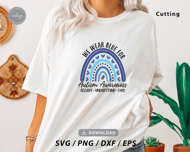 May include: A white t-shirt with a blue and white rainbow design and the text "We Wear Blue For Autism Awareness Accept Understand Love".