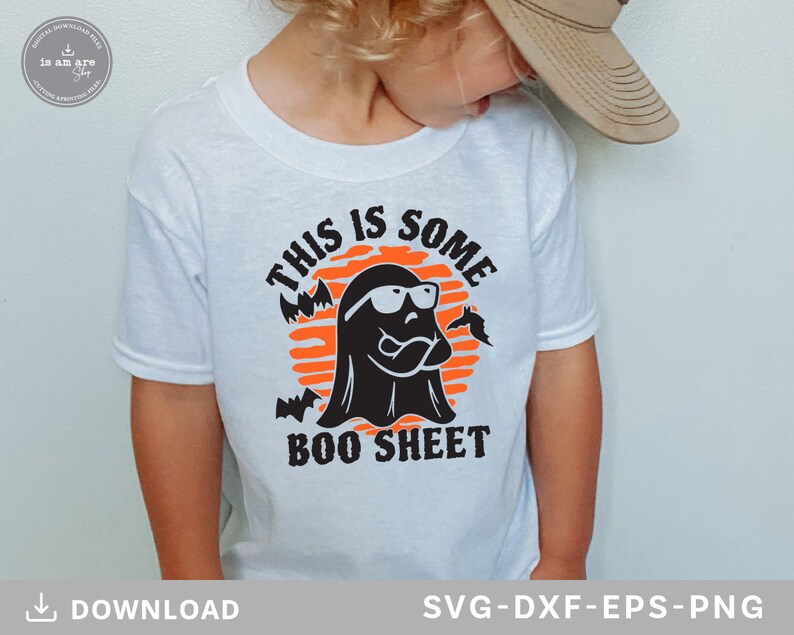 May include: White t-shirt featuring a Halloween-themed graphic. The design includes a black ghost wearing sunglasses, bats, and the text "THIS IS SOME BOO SHEET" in black and orange. The shirt is for digital download.