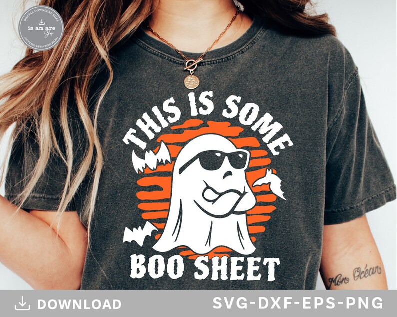 May include: Dark gray t-shirt with a Halloween-themed graphic. The design features a white ghost wearing sunglasses, with the text "THIS IS SOME BOO SHEET" in white and orange. Bats are also included in the design.
