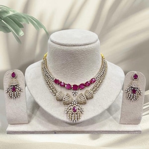Conjunto de collar gargantilla de lujo con piedra rubí, diamantes de circonita cúbica y pendientes de diseño: elegante joyería para la fiesta nupcial.