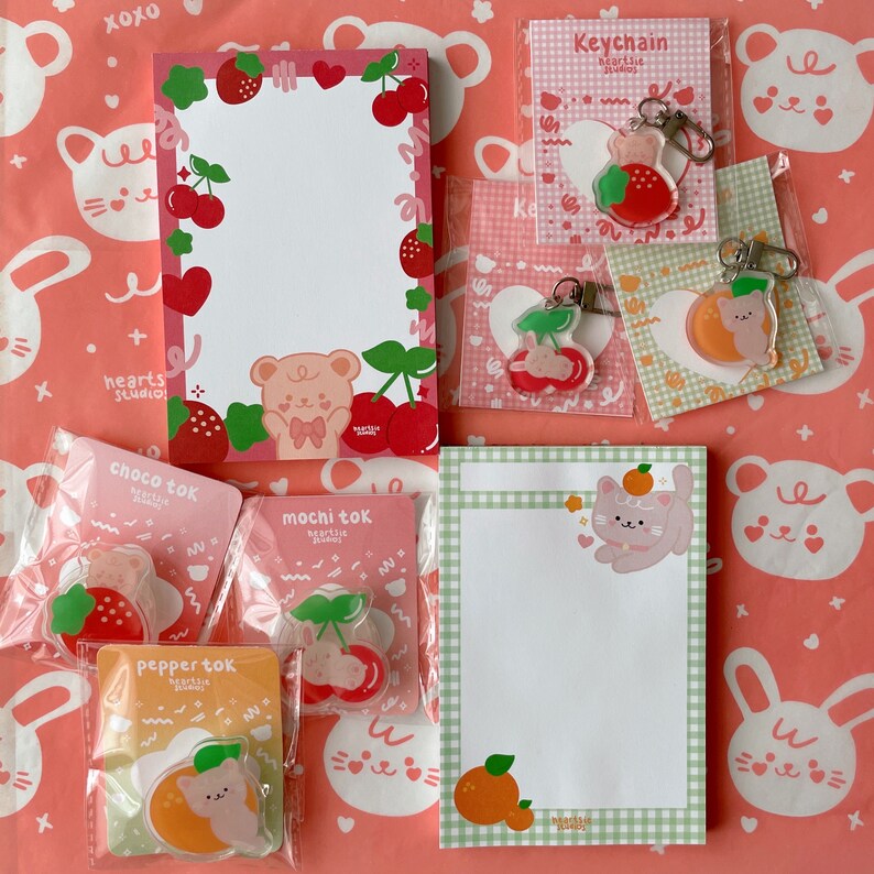 Pu&ograve; includere: Un set di articoli di cancelleria rosa e verde a tema fragola e gatto. Il set include un blocco note, un portachiavi e adesivi. Il blocco note ha uno sfondo rosa con un bordo bianco e un design a fragola. Il portachiavi &egrave; un ciondolo di plastica trasparente con un design a fragola e gatto. Gli adesivi sono rotondi e hanno una variet&agrave; di design, tra cui fragole, gatti e cuori.