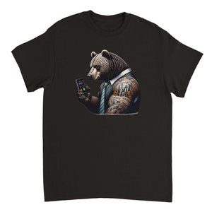 May include: A black t-shirt with a graphic of a brown bear wearing a suit and tie. The bear has a tattoo on its arm of a cityscape and dollar signs. The bear is holding a cell phone to its ear.