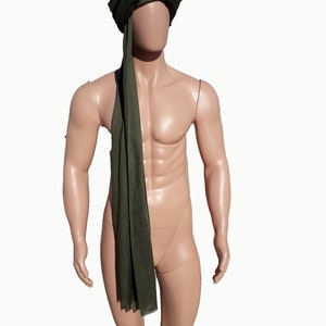 May include: A green turban with a long tail, worn by a mannequin.