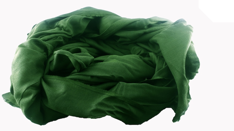 May include: A deep green fabric scarf is folded and bunched up, creating a soft, textured look.