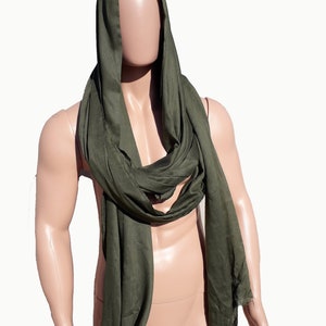May include: A dark green scarf made of a soft, flowing fabric. The scarf is draped around a mannequin's neck and shoulders, creating a hooded effect.
