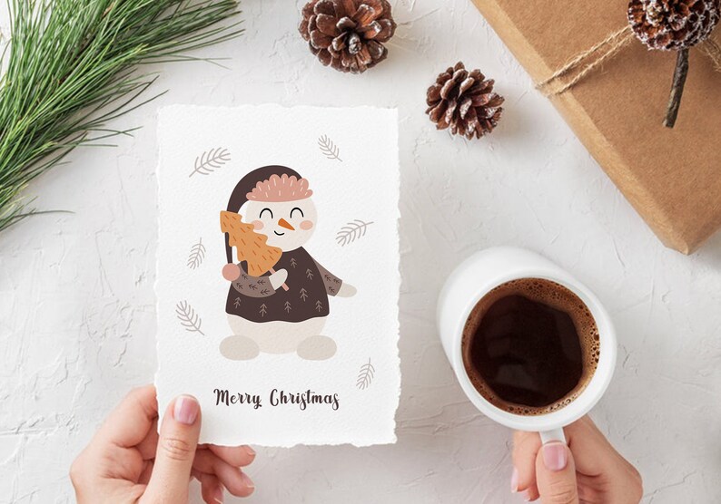 Pu&ograve; includere: Un biglietto bianco con un'illustrazione di un pupazzo di neve che tiene un piccolo albero arancione. Il pupazzo di neve indossa un cappello e un maglione marroni con un bordo bianco. Il biglietto ha il testo "Merry Christmas" scritto in corsivo nero.