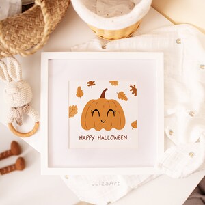 May include: A white framed print with a cute cartoon pumpkin with a smiling face and the text "Happy Halloween". The pumpkin is surrounded by orange and brown leaves.