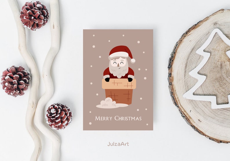 Puede incluir: Una tarjeta de Navidad con una ilustraci&oacute;n de dibujos animados de Pap&aacute; Noel en una chimenea. La tarjeta es marr&oacute;n con copos de nieve blancos y el texto "Feliz Navidad".