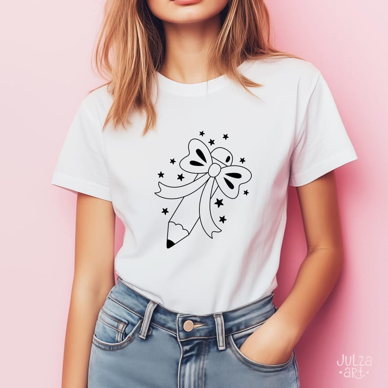 Op de afbeelding: Wit T-shirt met een zwart-witte afbeelding van een potlood, strik en sterren. Het ontwerp staat op de voorkant. De persoon draagt een blauwe spijkerbroek. Het T-shirt is van katoen.