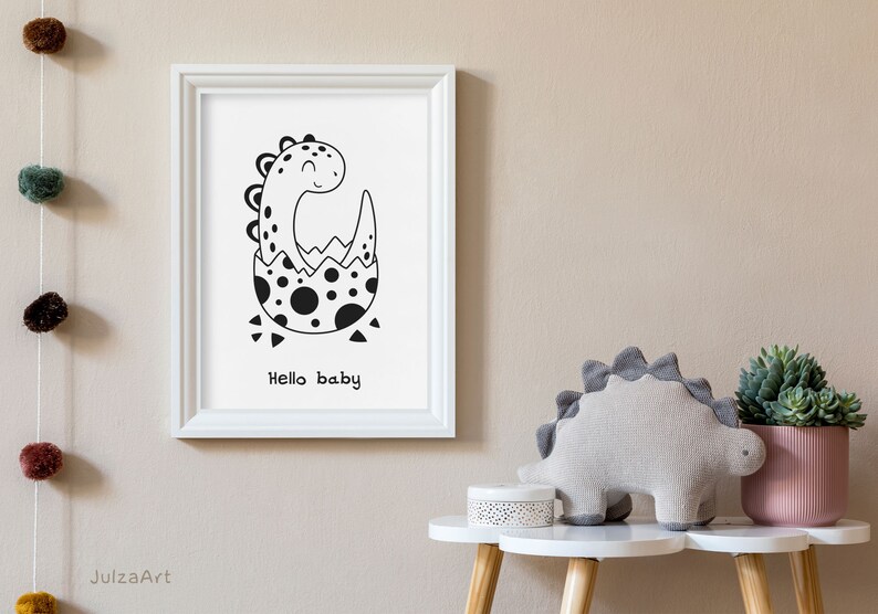 May include: Black and white illustration of a dinosaur hatching from an egg. The dinosaur is smiling and the text "Hello baby" is below the image.
