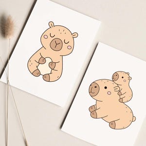 May include: Two art prints featuring cartoon bears in a minimalist style. One print shows a bear holding a heart, and the other shows a bear carrying a smaller bear on its back. The bears are light brown with black and pink accents.