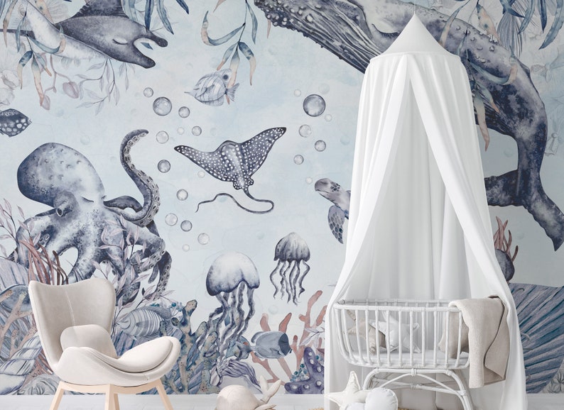 May include: A white canopy crib with a blue and gray watercolor mural featuring an octopus, stingray, jellyfish, and sea turtles. The mural is set against a light blue background with white bubbles.
