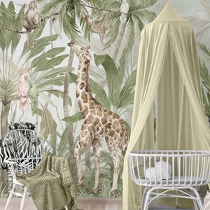 Peut inclure: Peinture murale à l'aquarelle représentant une scène de jungle avec une girafe, des singes, un zèbre et des perroquets. L'arrière-plan comprend des palmiers et une végétation luxuriante. Un berceau blanc et un auvent avec un drapé jaune clair sont au premier plan.