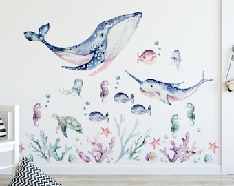 May include: A set of watercolor-style ocean animal wall decals featuring a blue whale, a narwhal, seahorses, a turtle, an octopus, starfish, and coral. The decals are perfect for adding a whimsical touch to a child's room or nursery.
