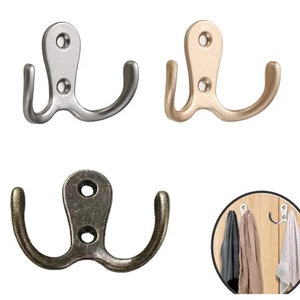 May include: Three double hooks in silver, gold, and antique bronze finishes. Each hook has two prongs for hanging items.