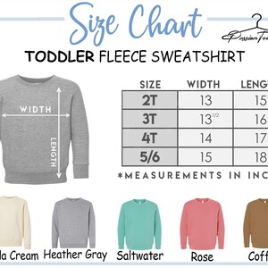 Peut inclure: Tableau des tailles pour les sweat-shirts en polaire pour tout-petits. Le tableau indique les mesures en pouces pour les tailles 2T, 3T, 4T et 5/6. L'image affiche &eacute;galement un sweat-shirt gris avec des indicateurs de largeur et de longueur.