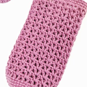A close-up of a pink crocheted fabric with a textured pattern.