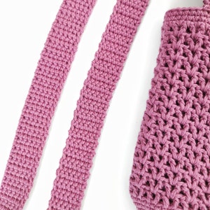 Two pink crocheted straps and a pink crocheted bag. The straps are made with a single crochet stitch and the bag is made with a more intricate stitch.