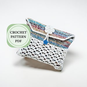 Puede incluir: Bolso de mano de ganchillo hecho a mano con una parte superior multicolor y una parte inferior calada blanca. El bolso de mano presenta un cierre de flor blanca y botón azul. El texto "CROCHET PATTERN PDF" está en un círculo verde.