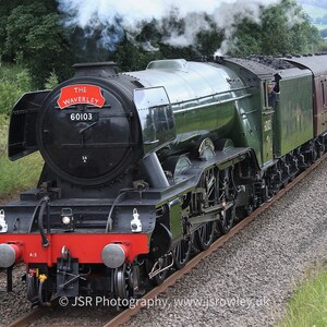 May include: A black steam locomotive with the name "The Waverley" and the number "60103" on the side. The locomotive is pulling a train of passenger cars.