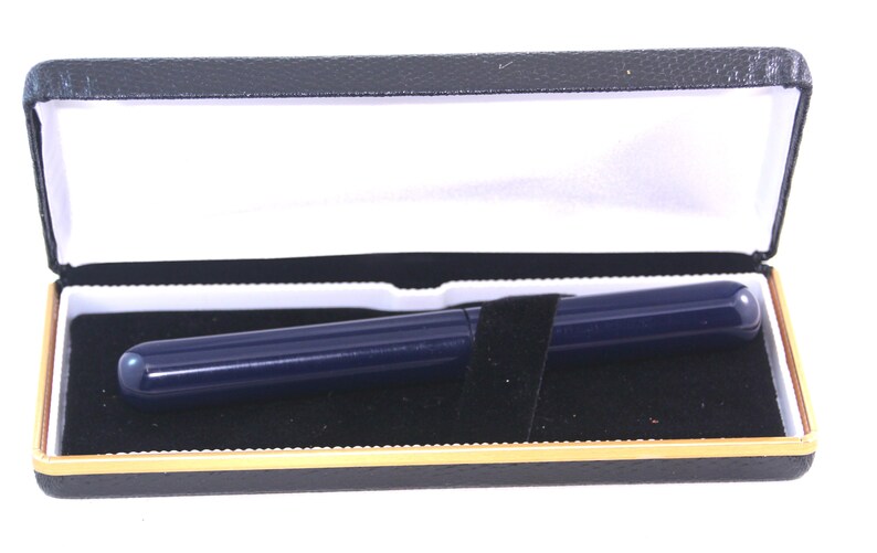 May include: A dark blue pen in a black velvet-lined box with a gold trim.