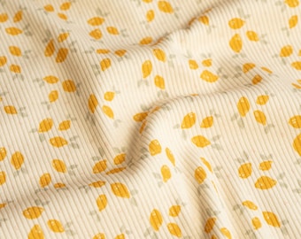 May include: A close-up of a cream-colored fabric with a repeating pattern of yellow lemons and green leaves. The fabric has a ribbed texture.