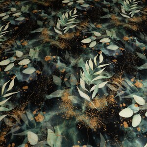May include: A dark green and gold fabric with a watercolour pattern of leaves and branches. The fabric has a subtle shimmer and a soft, flowing texture.