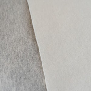 Puede incluir: Primer plano de dos muestras de tela, una gris y otra blanca. Las muestras est&aacute;n una al lado de la otra, con la muestra gris a la izquierda y la muestra blanca a la derecha.