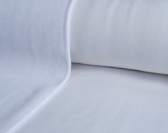 May include: Close-up of white fabric, showing a rolled section and a flat section. The fabric has a smooth, clean appearance, with a subtle texture visible on the rolled portion. The edges are neatly finished with a white trim.