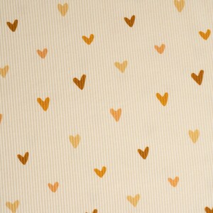 May include: A cream-colored fabric with a repeating pattern of brown and orange hearts.
