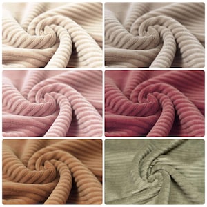 May include: Close-up of six fabric swatches in different colours. The fabric is a corduroy with a ribbed texture. The colours are beige, pink, brown, and green.