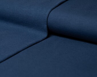 May include: Close-up of a folded piece of dark blue fabric. The fabric has a soft, textured surface.