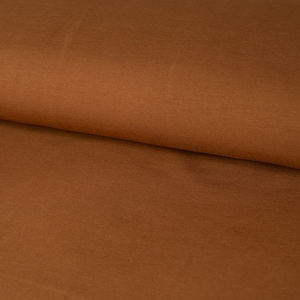 May include: A close-up of a brown fabric with a smooth texture. The fabric is folded in half, showing the inside and outside of the material.