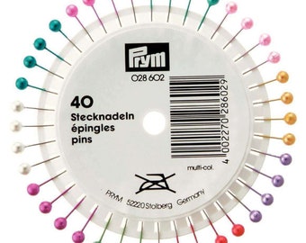 May include: A pack of 40 colorful sewing pins with plastic heads. The pins are arranged in a circle on a white card with the Prym brand name and product information. The card reads "40 Stecknadeln épingles pins" and "028 602".