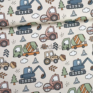 May include: Fabric with a repeating pattern of construction vehicles in shades of blue, brown, green, and tan. The design includes excavators, cement mixers, and road rollers, along with trees, clouds, and traffic cones on a cream background.