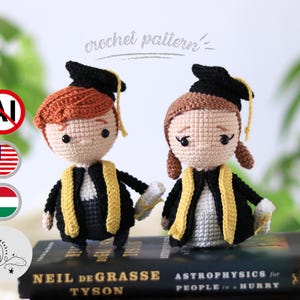 May include: Two crocheted graduation dolls, one with red hair and the other with brown hair, wearing black gowns with gold trim and mortarboards. The dolls are standing on top of books. The words "crochet pattern" are written above the dolls.