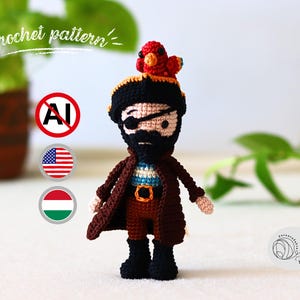 May include: A crocheted pirate doll with a black beard, eye patch, and a red parrot on his head. He wears a brown coat, black boots, and a tricorn hat. The doll is approximately 15 cm tall.