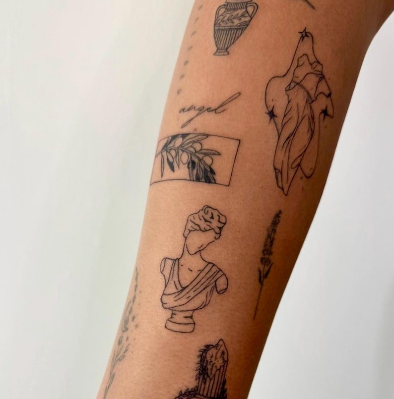 May include: A person's arm with several small black line drawings of various images including an olive branch, a vase, a bust of a woman, a plant, and a figure with stars. The word "angel" is written in cursive.