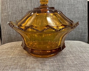 May include: Amber glass candy dish with a scalloped edge and a lid with a knob on top.