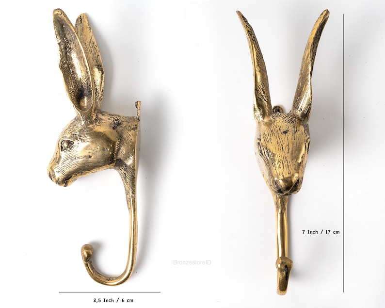 May include: A gold-toned metal rabbit head wall hook with a hook extending from the bottom. The hook is 7 inches tall and 2.5 inches wide.