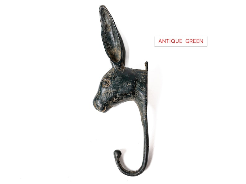 May include: Antique green rabbit head wall hook. The hook is shaped like a rabbit's head with long ears and a curved hook.